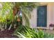 Home's entry with a dark green front door and landscaped plants nearby, complemented by a brick walkway at 4567 Whispering Oaks Dr, North Port, FL 34287