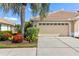A well-maintained two-car garage with a tile roof sits next to a palm tree in the front yard at 4567 Whispering Oaks Dr, North Port, FL 34287