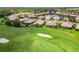 An aerial view of a lush green golf course surrounded by beautiful homes and a pond at 4567 Whispering Oaks Dr, North Port, FL 34287