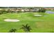 A lush green golf course with sand traps surrounded by homes and trees at 4567 Whispering Oaks Dr, North Port, FL 34287