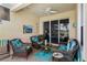Covered lanai with cozy wicker furniture and tranquil views of lush backyard landscaping at 4567 Whispering Oaks Dr, North Port, FL 34287
