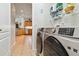 Modern laundry area featuring new appliances with the kitchen visible in the background at 4567 Whispering Oaks Dr, North Port, FL 34287