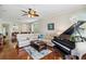 Spacious living room featuring hardwood floors, a grand piano, and comfortable seating at 4567 Whispering Oaks Dr, North Port, FL 34287