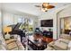 Hardwood floor living room with ceiling fan, piano, and access to the screened pool at 4567 Whispering Oaks Dr, North Port, FL 34287