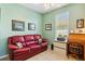 Cozy office features a comfortable red couch, window, and wooden desk at 4567 Whispering Oaks Dr, North Port, FL 34287
