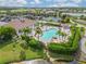Beautiful community pool area surrounded by lush landscaping, tennis courts, and a community center at 4567 Whispering Oaks Dr, North Port, FL 34287