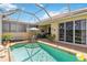 Sparkling pool with covered lanai, patio furniture and lush landscaping at 4567 Whispering Oaks Dr, North Port, FL 34287