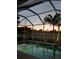 Inviting pool surrounded by lush tropical landscaping with screened-in enclosure, creating a serene outdoor space at 4567 Whispering Oaks Dr, North Port, FL 34287