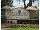 Close-up view of the Heron Creek Golf & Country Club entrance sign surrounded by colorful flowers at 4567 Whispering Oaks Dr, North Port, FL 34287