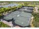 Aerial view of multiple tennis courts with manicured landscaping, ponds, and residential homes nearby at 4567 Whispering Oaks Dr, North Port, FL 34287