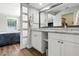 Bright bathroom with a double sink vanity, granite counters, and adjacent bedroom at 5052 Kingsley Rd, North Port, FL 34287