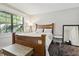Charming bedroom with wooden bed frame, side table, and large window offering plenty of natural light at 5052 Kingsley Rd, North Port, FL 34287