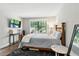 Bright bedroom featuring a view of the outdoors from the large window and hardwood floors at 5052 Kingsley Rd, North Port, FL 34287
