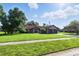 Charming single-story home with a lush green lawn, mature trees, and a two-car garage at 5052 Kingsley Rd, North Port, FL 34287
