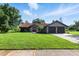Charming single-story home with a lush green lawn, mature trees, and a two-car garage at 5052 Kingsley Rd, North Port, FL 34287