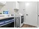 Modern laundry room with front load washer and dryer maximizing space, and enhancing the home's functionality at 5052 Kingsley Rd, North Port, FL 34287