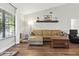 Cozy living room with hardwood floors, leather sofa, and a large window at 5052 Kingsley Rd, North Port, FL 34287