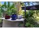 This outdoor kitchen features a built-in grill, countertop space and sunshade in a lush, tropical setting at 5052 Kingsley Rd, North Port, FL 34287