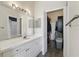 Bright bathroom featuring a spacious vanity with a large mirror and a walk-in closet with ample storage space at 5146 Northridge Rd # 305, Sarasota, FL 34238
