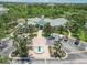 Aerial view of clubhouse featuring well-manicured landscaping, a water feature, and convenient parking spaces at 5146 Northridge Rd # 305, Sarasota, FL 34238