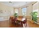 Dining room with wood table, eight chairs, wood floor, and multiple windows at 5146 Northridge Rd # 305, Sarasota, FL 34238