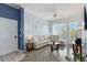 Bright living room with light walls, laminate flooring, white furniture, and sliding glass doors at 5146 Northridge Rd # 305, Sarasota, FL 34238