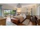 Bedroom with wood floors, sliding glass doors to deck, two dressers and wood chest at 5230 Lake Arrowhead Trl # 29, Sarasota, FL 34231