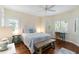 Well-lit bedroom with hardwood floors, a ceiling fan, plantation shutters, and a quaint writing desk at 5230 Lake Arrowhead Trl # 29, Sarasota, FL 34231