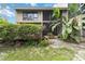 Exterior of a two-story home with tropical plants, a screened porch and an outdoor deck at 5230 Lake Arrowhead Trl # 29, Sarasota, FL 34231