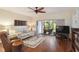 Comfortable living room with hardwood floors, a ceiling fan, and sliding glass doors leading to an outdoor patio at 5230 Lake Arrowhead Trl # 29, Sarasota, FL 34231