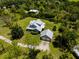 An aerial view of the home, detached garage, and pond surrounded by beautiful trees at 5242 Blackjack Cir, Punta Gorda, FL 33982