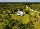Wide aerial shot of a home with lush, dense surrounding trees and a sprawling lawn at 5242 Blackjack Cir, Punta Gorda, FL 33982