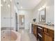 A spacious bathroom featuring a tub, wooden cabinets and granite countertops at 5242 Blackjack Cir, Punta Gorda, FL 33982