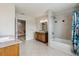 Large neutral bathroom with double sink, tub/shower combo and stone countertops at 5242 Blackjack Cir, Punta Gorda, FL 33982