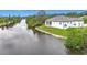 Aerial view of home situated on a canal with a well-maintained lawn at 576 Mcdill Dr, Port Charlotte, FL 33953