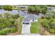 Aerial view of a white house that features a paver driveway, two car garage, and water access at 576 Mcdill Dr, Port Charlotte, FL 33953