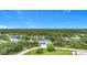 A high angle of the white house showing the roof, driveway, and luscious green trees at 576 Mcdill Dr, Port Charlotte, FL 33953