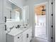 Bathroom with a modern vanity, stylish mirror, and a glimpse of an outdoor patio with a ceiling fan at 576 Mcdill Dr, Port Charlotte, FL 33953