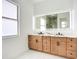 Bright bathroom featuring double vanity with a modern, lighted mirror at 576 Mcdill Dr, Port Charlotte, FL 33953