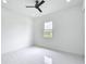 Minimalist bedroom with a ceiling fan, a bright window offering outdoor views, and neutral decor at 576 Mcdill Dr, Port Charlotte, FL 33953