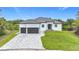 Beautiful new construction home with a paver driveway, two-car garage, and lush landscaping at 576 Mcdill Dr, Port Charlotte, FL 33953