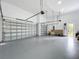 Spacious three car garage featuring epoxy floors and white walls at 576 Mcdill Dr, Port Charlotte, FL 33953