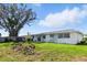 Backyard with ample green space, and a glimpse of the exterior home at 6196 Mayberry Ave, North Port, FL 34287