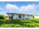 The backyard featuring a white house and grass at 6196 Mayberry Ave, North Port, FL 34287