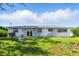 The backyard featuring a white house and grass at 6196 Mayberry Ave, North Port, FL 34287