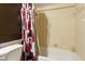 Bathroom with a bathtub and shower combination and red and black flower shower curtain at 6196 Mayberry Ave, North Port, FL 34287