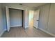 Cozy bedroom with light walls, wood-look flooring, a closet, and a doorway to another room at 7052 Legion St, Port Charlotte, FL 33981