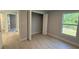 Bright bedroom featuring wood-look floors, a large closet, and a sunny window overlooking greenery at 7052 Legion St, Port Charlotte, FL 33981