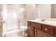 Bathroom showcasing a glass-enclosed shower, neutral tile, and a classic vanity with a white sink at 8098 Moonstone Dr # 17-203, Sarasota, FL 34233