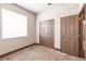 This bedroom features a large window, carpet flooring, and a double-door closet at 8098 Moonstone Dr # 17-203, Sarasota, FL 34233